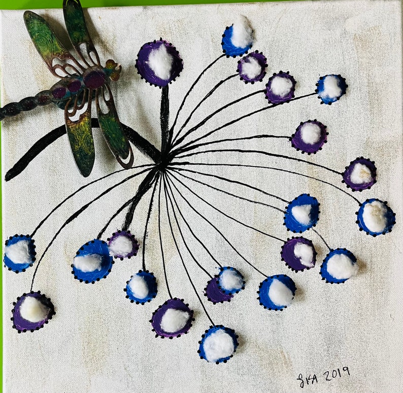 Peut inclure: Une toile blanche avec un motif abstrait noir et blanc repr&eacute;sentant une libellule en m&eacute;tal aux accents verts et bruns. Le motif rappelle un pissenlit avec des boules de coton blanches repr&eacute;sentant les graines. La toile est sign&eacute;e "SKA 2019" dans le coin inf&eacute;rieur droit.
