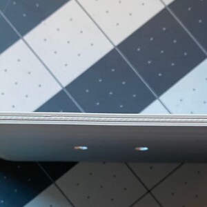 May include: A white, rectangular tray with a slightly curved design. The tray has a series of small holes and a textured edge. The tray is made of a light-colored material and appears to be new.