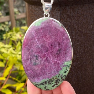 May include: Oval-shaped pendant with a green and purple gemstone set in sterling silver.