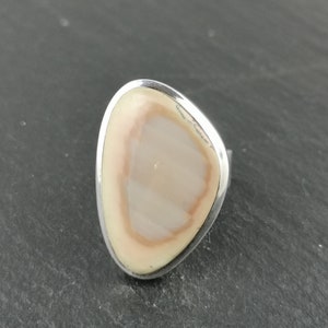 K&ouml;nnte beinhalten: Ein silberner Ring mit einem ovalen, hellbraunen Stein in der Mitte.