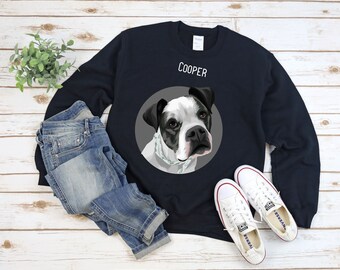 May include: A navy blue sweatshirt with a white circle containing a black and white illustration of a dog. The dog is wearing a white bandana. The text "COOPER" is printed in white above the circle.