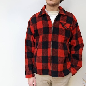 May include: A red and black plaid flannel shirt with a zipper closure. The shirt has a patch pocket on the left chest.