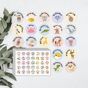 Könnte beinhalten: Ein Set mit 50 bunten runden Stickern mit verschiedenen Tieren und aufmunternden Sprüchen auf Deutsch. Die Sticker sind perfekt für Lehrer, Eltern oder alle, die ihrem Tag eine Prise Spaß und Ermutigung hinzufügen möchten.