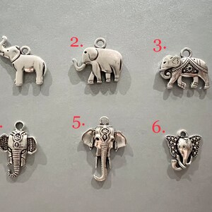 May include: Six silver elephant charms with intricate details. The charms are numbered 1 through 6.