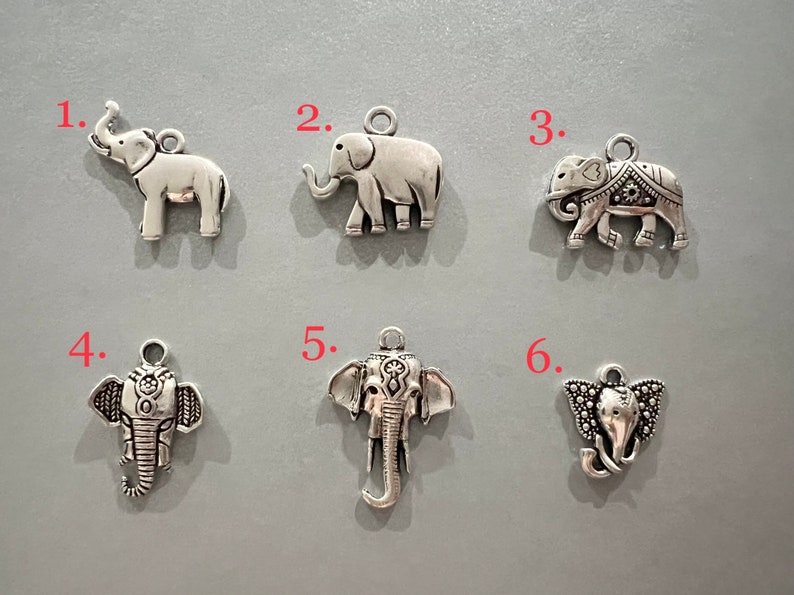 May include: Six silver elephant charms with intricate details. The charms are numbered 1 through 6.