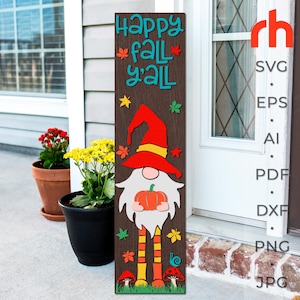 May include: A wooden sign with the text "Happy Fall Y'all" and a gnome holding a pumpkin. The gnome is wearing a red hat with a yellow brim and a white beard. The sign is decorated with fall leaves and mushrooms.