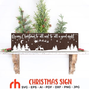 May include: A brown wooden Christmas sign with the text "Merry Christmas to all and to all a good night". The sign features a white silhouette of trees, deer, Santa's sleigh, stars, and a crescent moon. The sign has a white border and is rectangular.