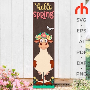 May include: A wooden sign with the text "hello spring" in pink and yellow letters. A cartoon cow with a flower crown is standing in front of the sign. The cow is brown and white with a pink nose and black eyes.