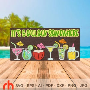 May include: A wooden sign with the phrase "IT'S 5 O'CLOCK SOMEWHERE" in green lettering. Below the text are colorful illustrations of cocktails, including a margarita, a drink in a coconut, and a mason jar. The sign is on a wooden surface with a beach and ocean background.