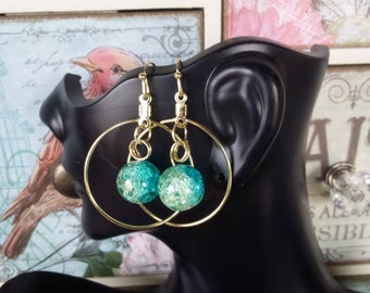 1.75 Gold toned Hoops with single large 10 cm hanging Crackle/Shattered Glass Bead. Beautiful Peacock Palette Blue/Green