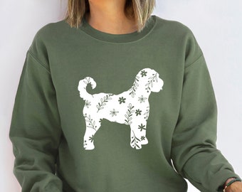 Könnte beinhalten: Ein grünes Sweatshirt mit einer weißen Silhouette eines Hundes mit einem Blumenmuster. Der Hund steht auf allen vieren und hat seinen Schwanz eingerollt.