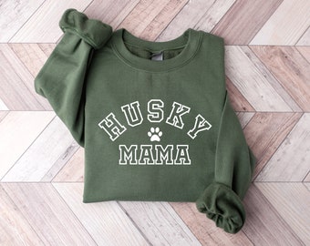 Może przedstawiać: Zielony sweter z napisem "HUSKY MAMA" w kolorze białym z odciskiem łapy w środku napisu.