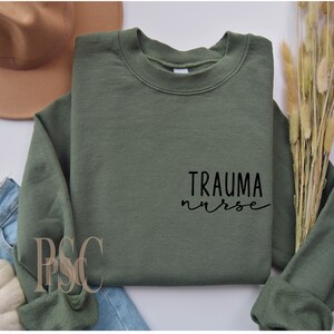 May include: A green sweatshirt with the text "Trauma nurse" in black lettering.