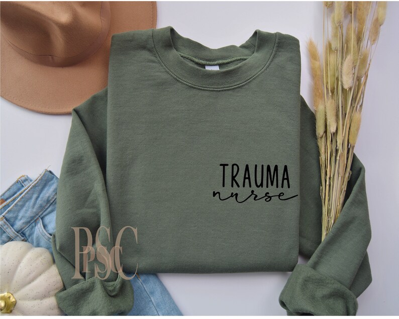 May include: A green sweatshirt with the text "Trauma nurse" in black lettering.