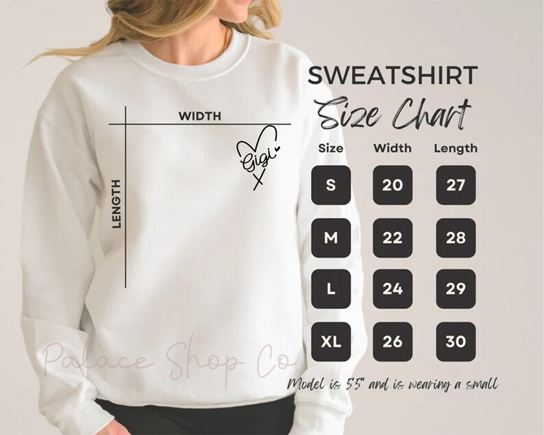 May include: White sweatshirt with a size chart showing measurements in inches. The chart includes sizes S, M, L, and XL with corresponding width and length measurements. The text "Gigi" is written on the sweatshirt with a heart.