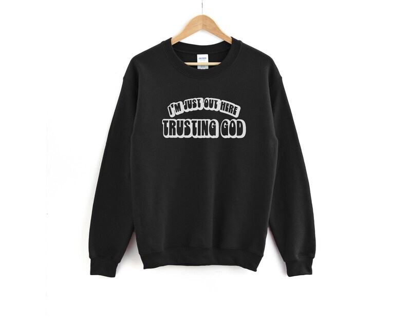 May include: Black sweatshirt with the text "I'm just out here trusting God" in white lettering.