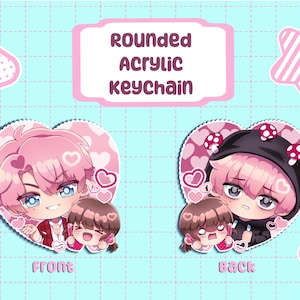May include: Two rounded acrylic keychains featuring anime-style characters. The left keychain shows a pink-haired character with a smaller brown-haired character. The right keychain shows a character in a black mushroom-themed hoodie. Text reads ROUNDED ACRYLIC KEYCHAIN.