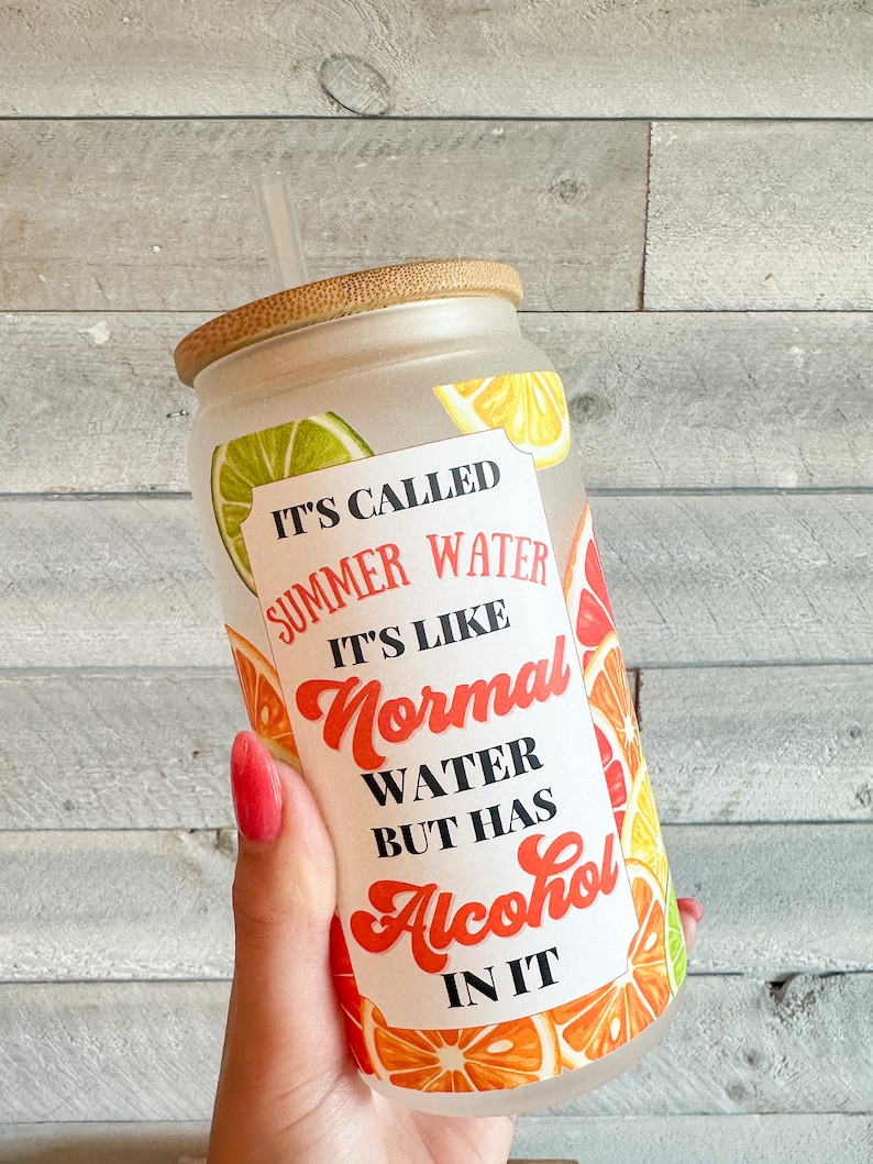 May include: A frosted glass tumbler with a bamboo lid and a straw. The tumbler has a colorful citrus fruit design and the text "It's called summer water. It's like normal water but has alcohol in it."