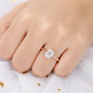 Op de afbeelding: Een verlovingsring van ros&eacute;goud met een grote ovale diamant.