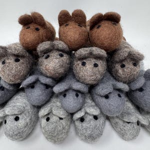 K&ouml;nnte beinhalten: Eine Sammlung handgefertigter Tierfiguren aus Filz, darunter Schafe und Pferde. Die Schafe sind haupts&auml;chlich grau, w&auml;hrend die Pferde braun sind. Jede Figur hat kleine schwarze Augen und ist mit detaillierten Wollstrukturen gefertigt.