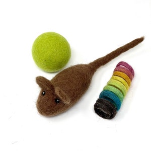 May include: A brown felt mouse toy with black bead eyes, a green felt ball, and a rainbow-colored felt ring toy. The toys are designed for cats and are set against a white background.