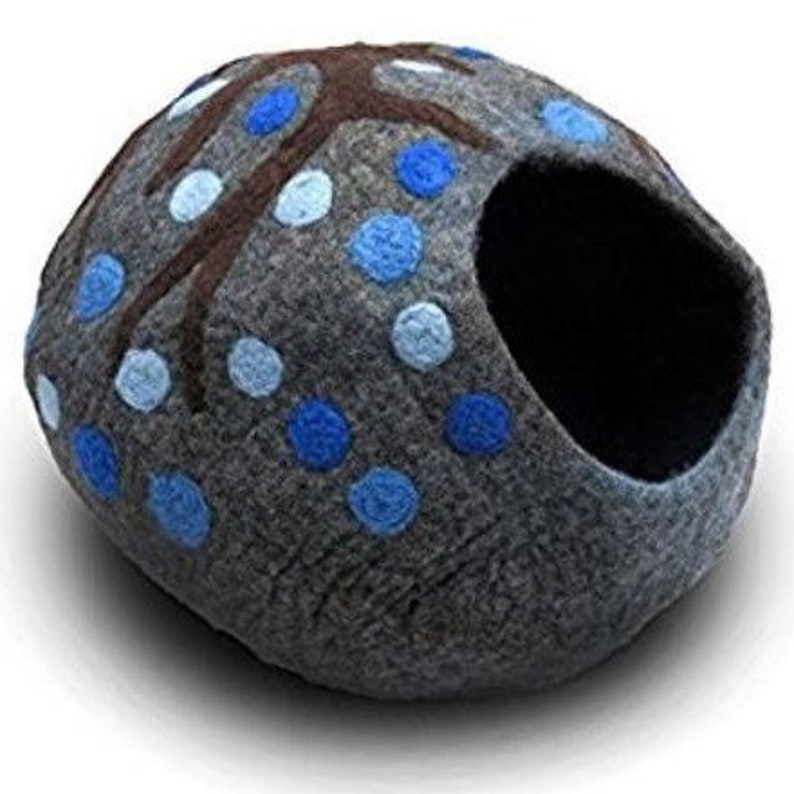 May include: A gray felt cat bed shaped like a dome with a large opening. The bed is decorated with a brown tree design and blue and light blue polka dots.