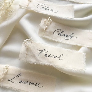 Marque place mariage avec fleurs et calligraphie, porte noms en tissu, marque place bohème