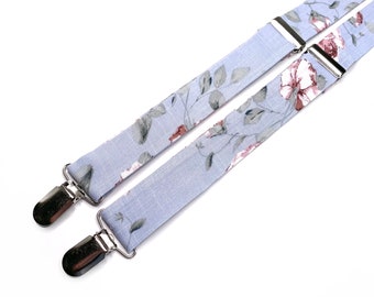 May include: A pair of light blue suspenders with a floral pattern. The suspenders have silver clips.