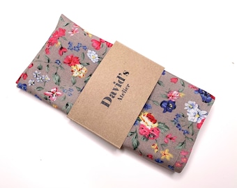 May include: A gray floral patterned pocket square with a brown paper tag that reads "David's Atelier".
