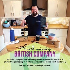 May include: A man holding an award in a kitchen setting. The award is a black plaque with the text "The Product Scout" on it. The man is smiling and holding a wooden utensil in his other hand. There are various eco-friendly products on the table in front of him, including a blue water bottle, a stainless steel cup, and a bamboo utensil set. The text "Award winning BRITISH COMPANY" is displayed on the table in front of the man. The text "We offer a range of award winning sustainably sourced products in plastic free packaging. If you have any questions please reach out to us :) Gerwyn Holmes - EcoSlurps Founder" is also displayed on the table.