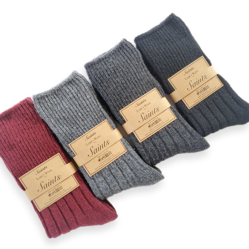 K&ouml;nnte beinhalten: Vier Paar gerippte Socken in Burgunderrot, Grau, Dunkelgrau und Schwarz. Jedes Paar hat ein braunes Papieretikett mit dem aufgedruckten Text "Saints Lamb's Wool Saints".