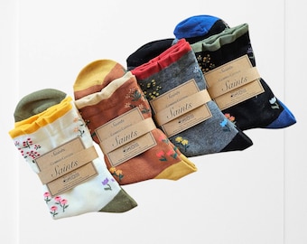 May include: A set of five pairs of socks with floral patterns. The socks are made of combed cotton and have a ribbed cuff. The socks are packaged in a clear plastic bag with a brown paper tag that says "Saints Combed Cotton Saints".