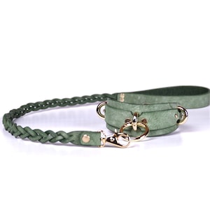 May include: A green leather dog collar and leash set. The collar has gold-colored hardware and a matching leash with a braided design. The set is made of a soft, suede-like material.