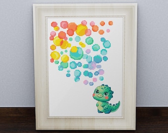 May include: A cross-stitch pattern featuring a green dinosaur blowing rainbow bubbles. The dinosaur is smiling and has a pink blush on its cheeks. The bubbles are arranged in a heart shape.