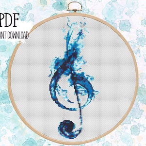 May include: A cross-stitch pattern of a treble clef in shades of blue, set within a wooden embroidery hoop. The words "PDF" and "INSTANT DOWNLOAD" are printed in black at the top left. The background has a watercolor effect.