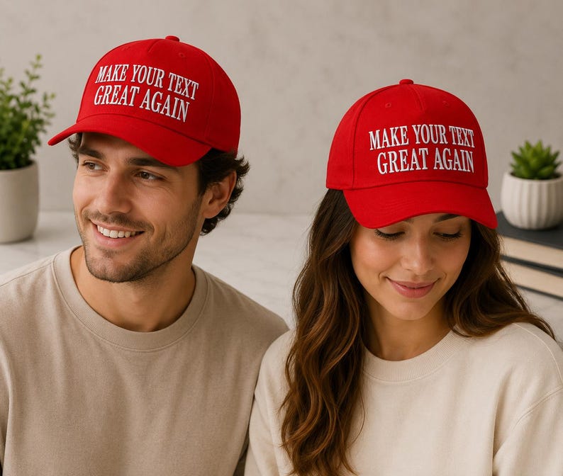 Może przedstawiać: Dwie osoby w czerwonych czapkach bejsbolowych z białym napisem "MAKE YOUR TEXT GREAT AGAIN". Czapki mają zakrzywiony daszek i strukturalną koronę. Osoby te mają na sobie koszulki w neutralnych kolorach.