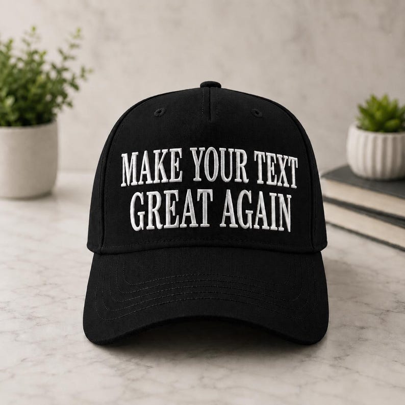 Może przedstawiać: Czarna czapka bejsbolowa z białym haftowanym napisem "MAKE YOUR TEXT GREAT AGAIN". Czapka ma zakrzywiony daszek i guzik na g&oacute;rze. Klasyczny styl.