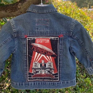 Może przedstawiać: Niebieska kurtka dżinsowa z naszywką Led Zeppelin Mothership w kolorze czerwonym, białym i czarnym na plecach.