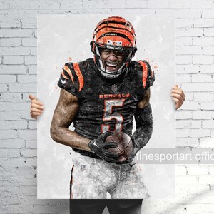 May include: A watercolor-style print of a football player in a black and orange uniform, holding a football. The player wears a helmet and the jersey displays the number 5 and the word "Bengals". The background is a light, abstract design.