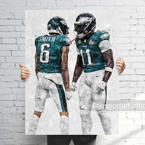 May include: Two American football players wearing green and white uniforms with the number 6 and 11 on their jerseys. The players are standing next to each other and appear to be celebrating a victory. The background is a white wall with the text "finesportart official" at the bottom.