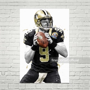 Könnte beinhalten: Ein schwarzes und goldenes Footballtrikot mit der Nummer 9 auf der Vorderseite. Das Trikot hat ein Fleur-de-lis-Logo auf der linken Seite und ein weißes NFL-Logo auf der rechten Seite. Der Spieler trägt einen schwarzen Helm mit einem goldenen Fleur-de-lis-Logo. Der Hintergrund ist weiß mit goldenen Farbspritzern.