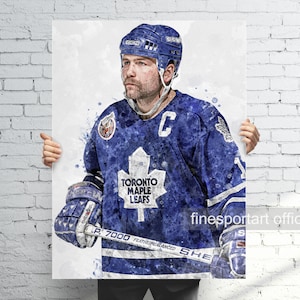 May include: A watercolor painting of a hockey player wearing a blue and white Toronto Maple Leafs jersey with the team logo on the front. The player is holding a hockey stick and wearing a helmet.