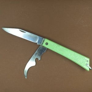 May include: A green pocket knife with a silver blade and a bottle opener. The handle has a floral design.