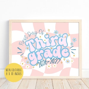 May include: A rectangular sign with a pink and white wavy checkerboard background. The text reads First Day Of Third grade 2026-2027 in blue and pink bubble letters. Small blue and white flowers and gold stars are scattered across the design.