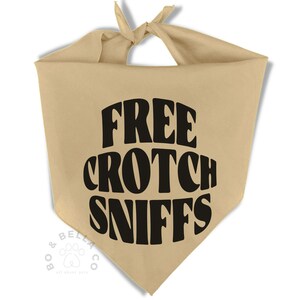 Op de afbeelding: Beige honden bandana met de tekst "FREE CROTCH SNIFFS" in grote, zwarte letters. De bandana is bovenaan vastgeknoopt en heeft een driehoekige vorm. Het Bo & Bella Co. logo is onderaan zichtbaar.