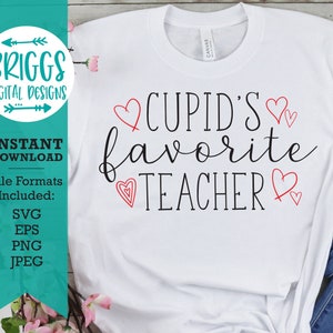 以下が含まれることがあります： 赤いハートがテキストの周りに書かれた、"CUPID'S favorite TEACHER"という黒いテキストが書かれた白いTシャツです。