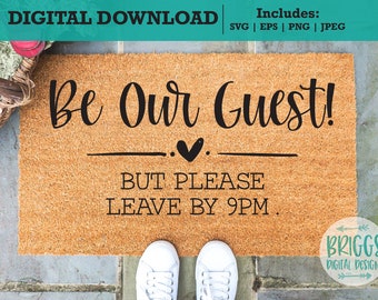 Könnte beinhalten: Eine braune Fußmatte mit dem Text "Be Our Guest!" und "But Please Leave By 9PM." in schwarzer Schrift. Ein kleines Herz befindet sich über der zweiten Textzeile.