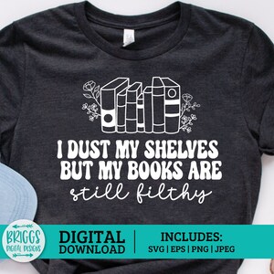 May include: A dark gray t-shirt with a white design featuring a stack of books with flowers and the text "I dust my shelves but my books are still filthy". The text is in a retro font style. The image also includes the text "Briggs Digital Designs" and "Digital Download" in the bottom left corner and "Includes: SVG | EPS | PNG | JPEG" in the bottom right corner.