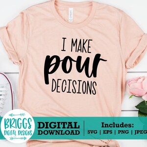 May include: A pink t-shirt with the text "I make pour decisions" in black lettering. The shirt is on a white wooden background with white sneakers and pink flowers.