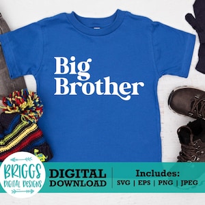May include: A blue t-shirt with the text "Big Brother" in white. The shirt is on a white wooden surface with a hat, jeans, and gloves around it.